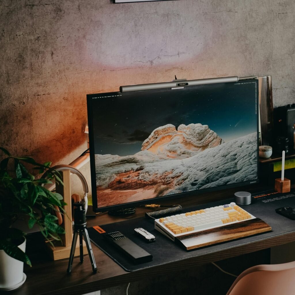 A tidy desk setup with monitor, keyboard, and plants, perfect for a modern home office.